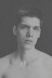 Zwart-wit foto van een mannelijk model dat in de camera kijkt.