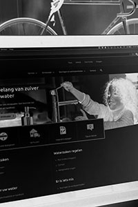 Zwart-wit foto van mijn laptop waarop de website van Evides te zien is. Deze heb ik tijdens een uitgebreid project opgebouwd en gemigreerd.